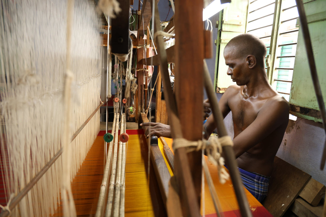 Indian artisan weaving handloom fabric on a traditional wooden loom for National Handloom Day, celebrating sustainable textiles and India's weaving heritage.