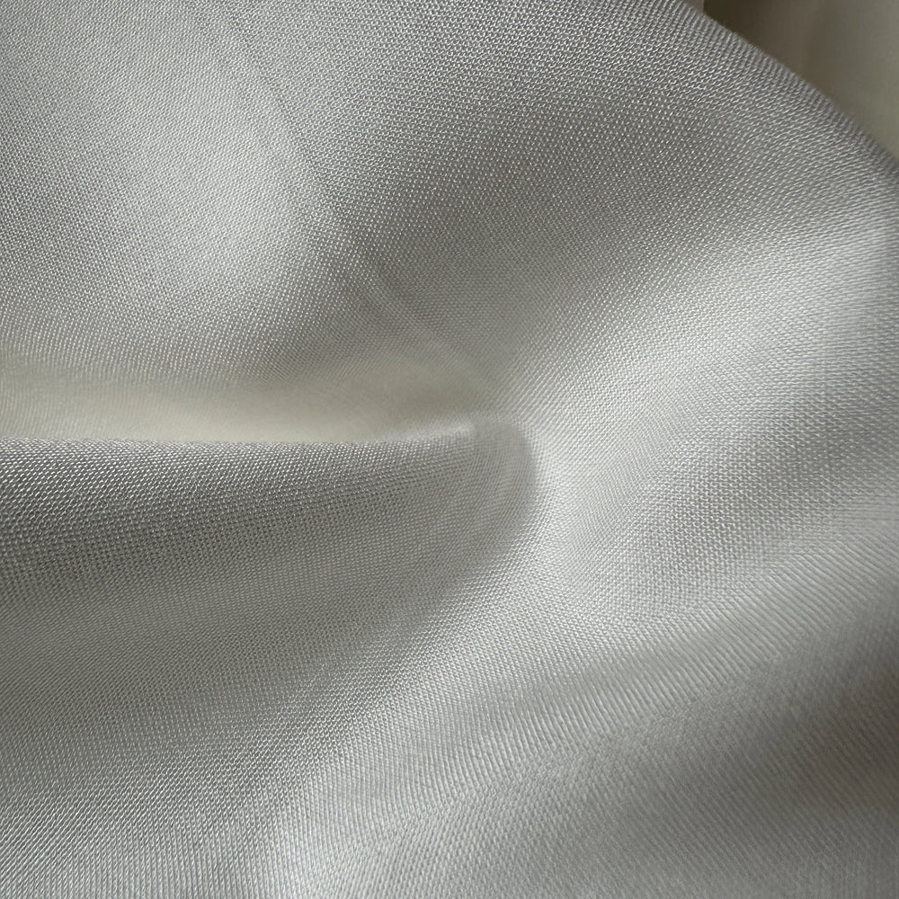 Close-up of 100% Aloe Vera plain fabric showing breathable plant-based textile texture for eco apparel.