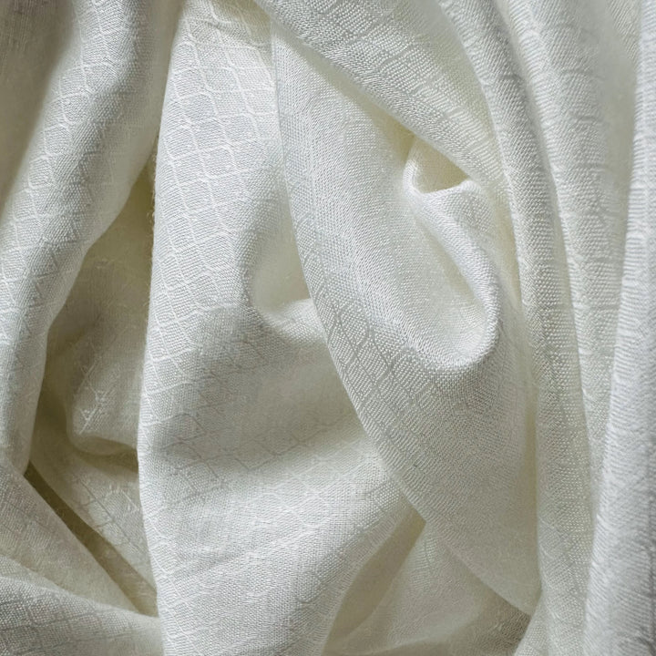 Fabric rolls of Jasmine cellulose stacked in a textile studio