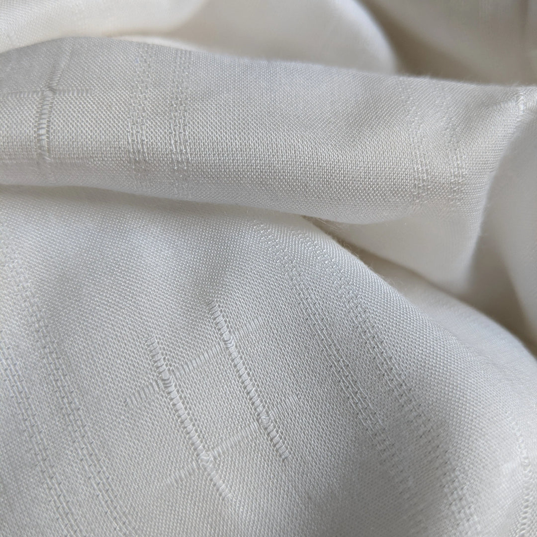 Folded stacks of milk fabric ready for sustainable garment manufacturing.