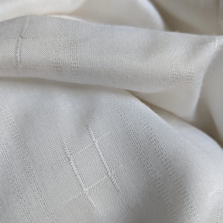 Folded stacks of milk fabric ready for sustainable garment manufacturing.