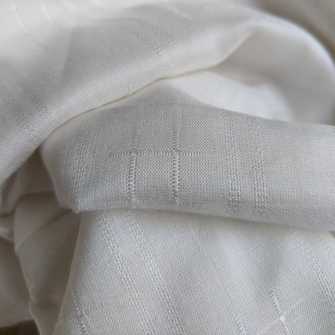 Minimalist display of milk fiber fabric swatch on a neutral background.