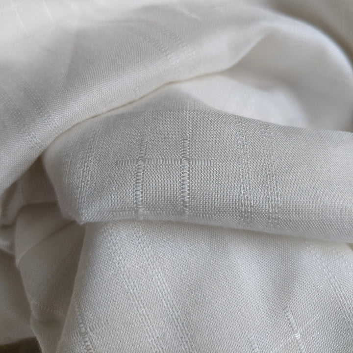 Minimalist display of milk fiber fabric swatch on a neutral background.