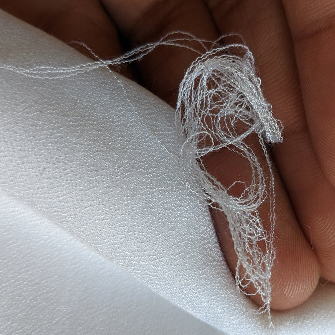 Hand touching milk fiber fabric, demonstrating its gentle and soft touch.