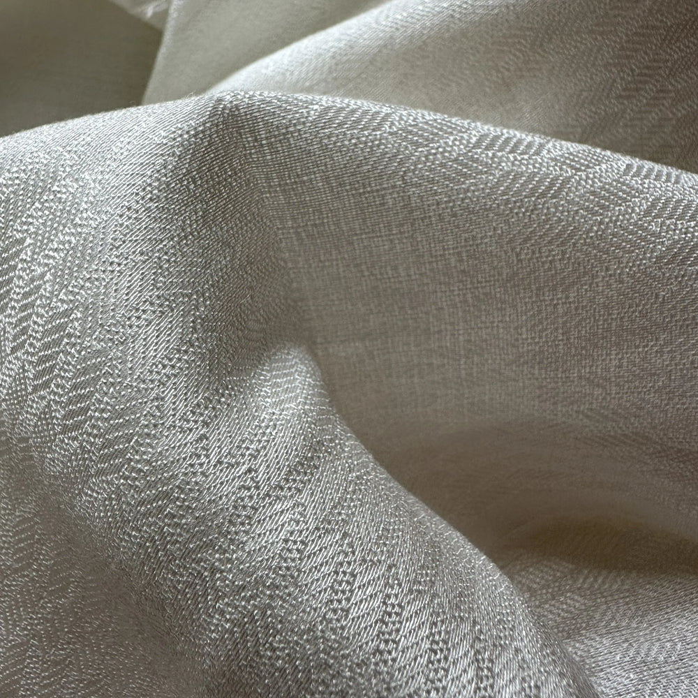 Close-up texture of 100% olive cellulose fabric showing lightweight breathable plant-based material.